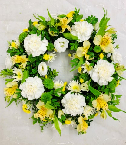 <h2>Classic Wreath in Yellow and Cream | Funeral Flowers</h2>
<ul>
<li>Approximate Size W 38cm H 38cm (standard)</li>
<li>Hand created yellow and cream wreath in fresh flowers</li>
<li>To give you the best we may occasionally need to make substitutes</li>
<li>Funeral Flowers will be delivered at least 2 hours before the funeral</li>
<li>For delivery area coverage see below</li>
</ul>
<br>
<h2>Liverpool Flower Delivery</h2>
<p>We have a wide selection of Funeral Wreaths offered for Liverpool Flower Delivery. Funeral Wreaths can be provided for you in Liverpool, Merseyside and we can organize Funeral flower deliveries for you nationwide. Funeral Flowers can be delivered to the Funeral directors or a house address. They can not be delivered to the crematorium or the church.</p>
<br>
<h2>Flower Delivery Coverage</h2>
<p>Our shop delivers funeral flowers to the following Liverpool postcodes L1 L2 L3 L4 L5 L6 L7 L8 L11 L12 L13 L14 L15 L16 L17 L18 L19 L24 L25 L26 L27 L36 L70 If your order is for an area outside of these we can organise delivery for you through our network of florists. We will ask them to make as close as possible to the image but because of the difference in stock and sundry items it may not be exact.</p>
<br>
<h2>Liverpool Funeral Flowers | Wreaths</h2>
<p>This striking wreath-shaped design has been loving handcrafted by our florists and features a classic selection of flowers including irises, carnations and spray chrysanthemums in yellows and creams are nestled into this traditional circular wreath.</p>
<br>
<p>A funeral wreath is flowers arranged in a circular shape with a hole in the centre. This circular shape symbolises the circle of life or eternal life. They are suitable for sending directly to a funeral whether you are family or a friend.</p>
<br>
<p>Contents of 12 inch oasis ring: 5 Iris, 5 Cream Carnations, 2 Cream Spray Chrysanthemums, 3 Cream Spray Carnations, Yellow Solidago, 2 Green Spray Chrysanthemums and mixed Foliage.</p>
<br>
<h2>Best Florist in Liverpool</h2>
<p>Trust Award-winning Liverpool Florist, Booker Flowers and Gifts, to deliver funeral flowers fitting for the occasion delivered in Liverpool, Merseyside and beyond. Our funeral flowers are handcrafted by our team of professional fully qualified who not only lovingly hand make our designs but hand-deliver them, ensuring all our customers are delighted with their flowers. Booker Flowers and Gifts your local Liverpool Flower shop.</p>
<br>
<p><em>Jane Catherine and Family - Review by Post - Funeral Florist Liverpool</em></p>
<br>
<p><em>Thank you so much for the amazing flowers you arranged for our mum she would have loved them. Love Jane, Catherine and family</em></p>
<br>